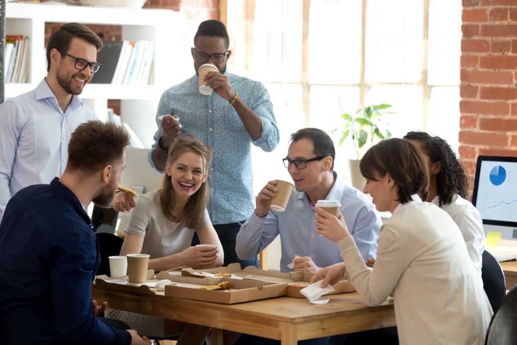 Happy diverse team talking having fun drinking coffee together