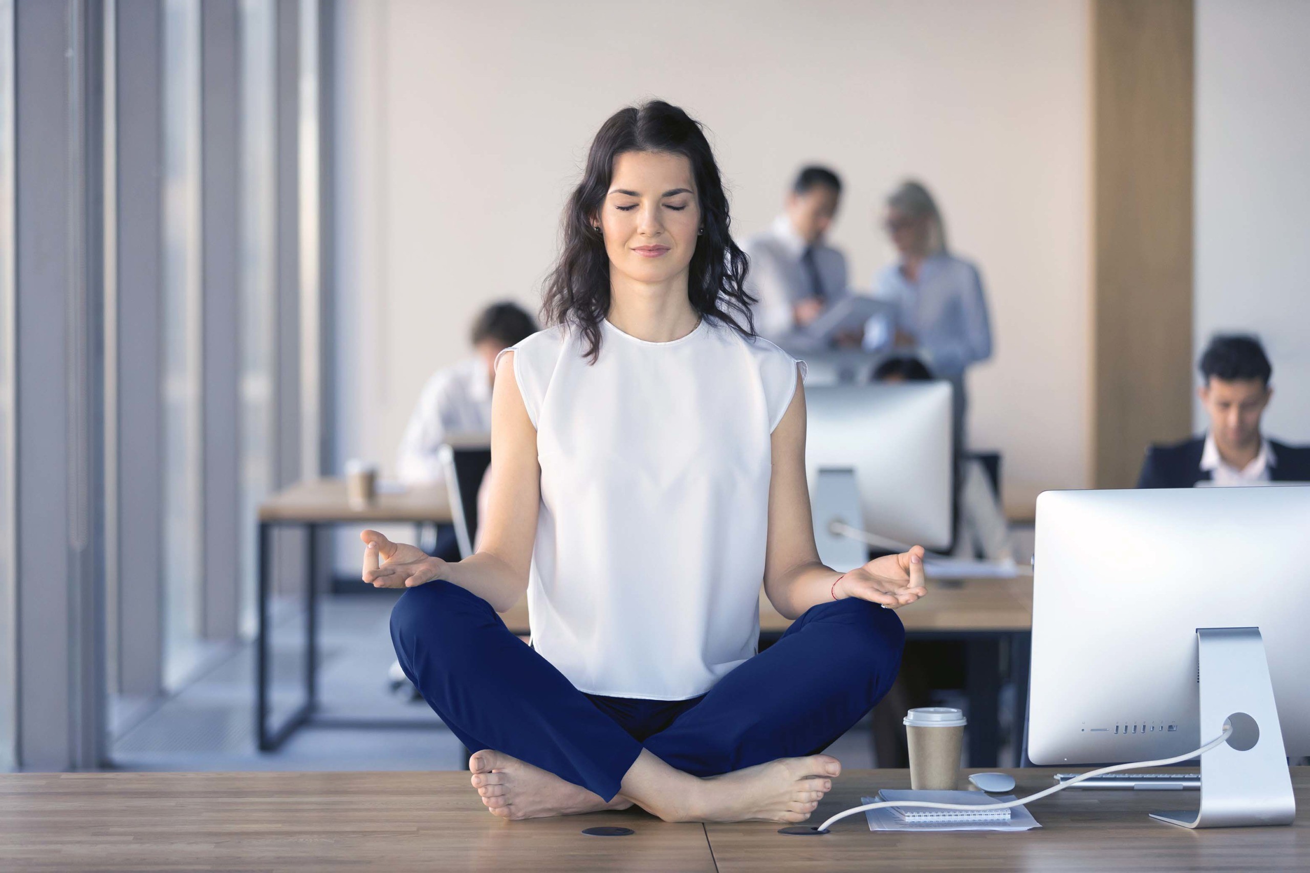 Woman meditating on desk at work